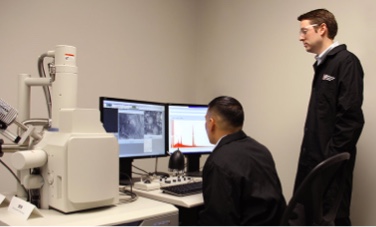 technicians work at computer and device analyzing composite material